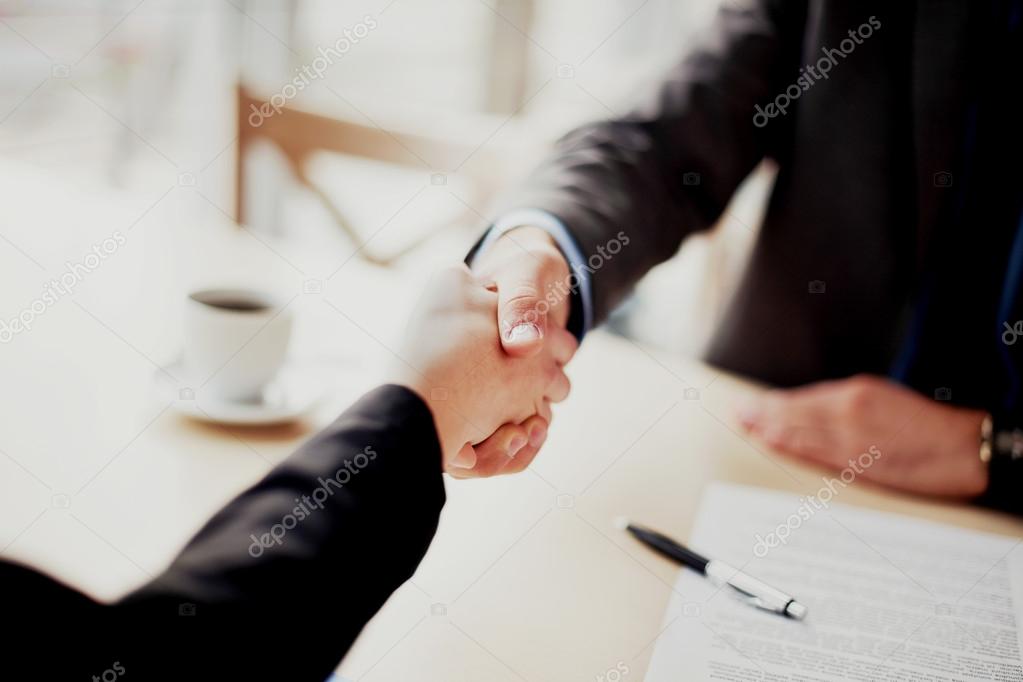 Poignée de main entre un négociant et un investisseur après signature de contrat